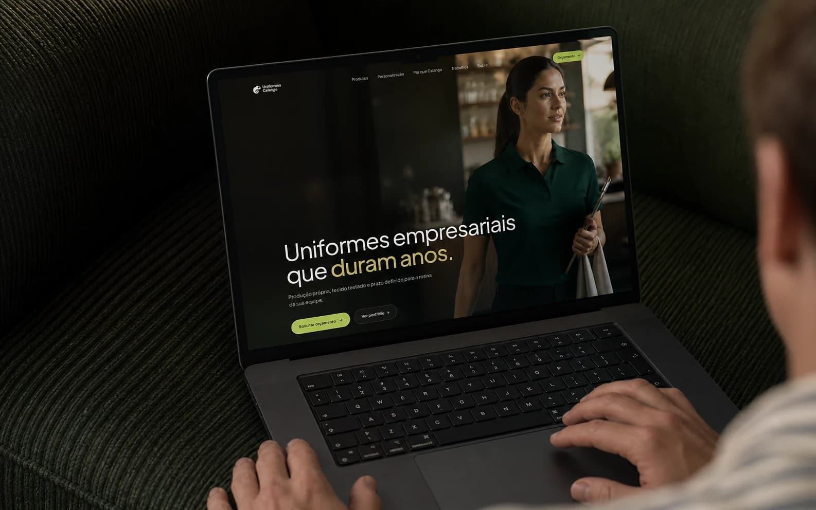Novo site da Uniformes Calango em um MacBook sobre um sofá verde