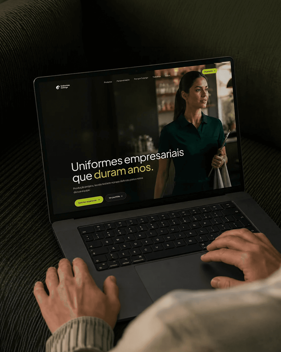Website Uniformes Calango em um MacBook nas mãos de uma pessoa
