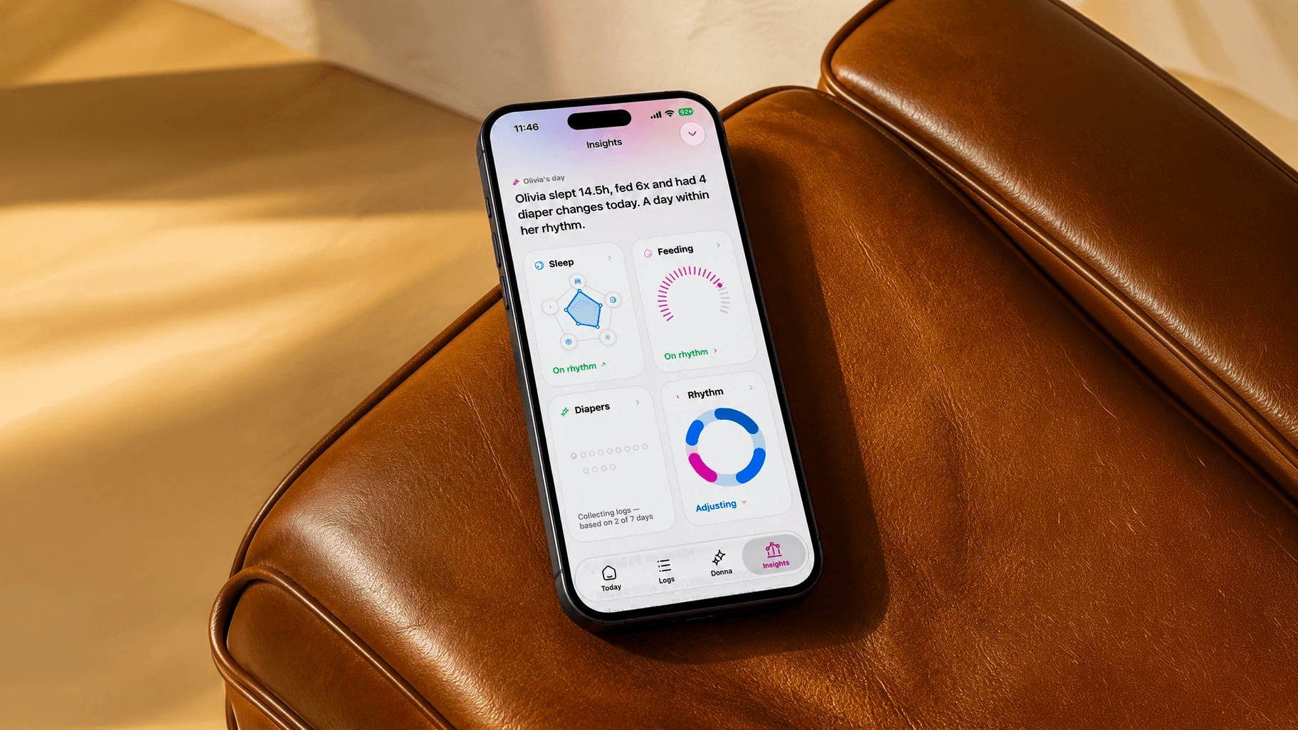 Tela de Insights da DonnaAI em um iPhone sobre uma poltrona de couro